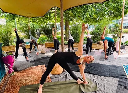 Ann geeft een groepsles yoga in open lucht